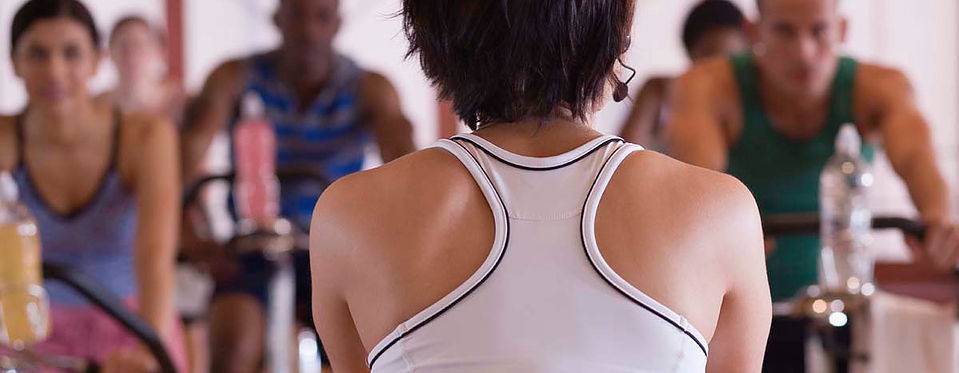 Rear view of instructor in spinning class